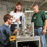 Students examining equipment with instructor